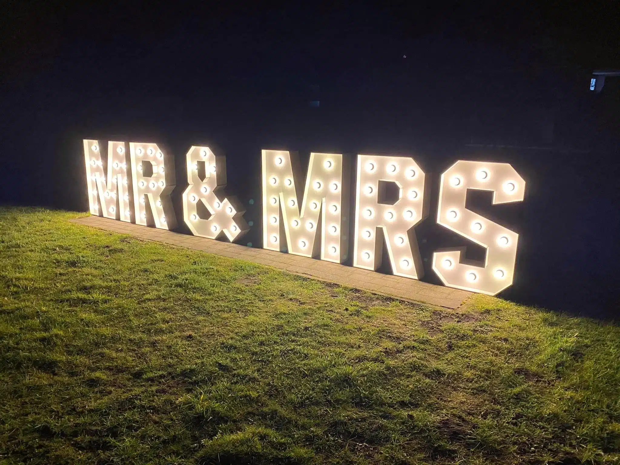 MR & MRS lichtletters buiten op het gras tijdens een avondfeest
